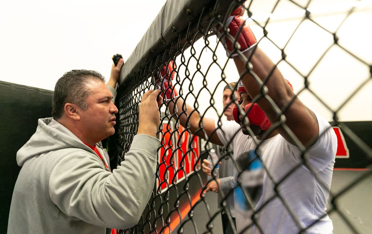 Javier Mendez coaching Daniel Cormier through the cage